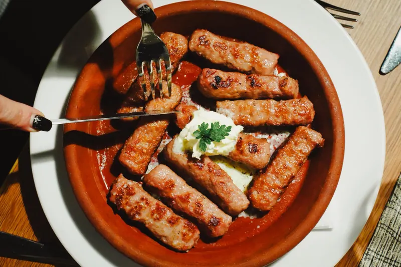 Ćevapi sa kajmakom u zemljanoj činiji